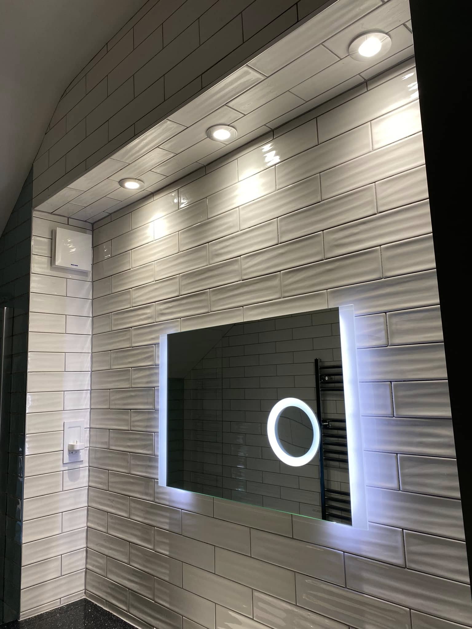 Bathroom with backlit mirror and bulkhead downlights