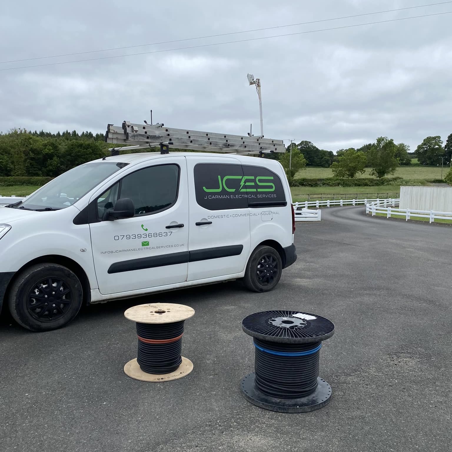 The J Carman Electrical Services van loaded with cable drums on site